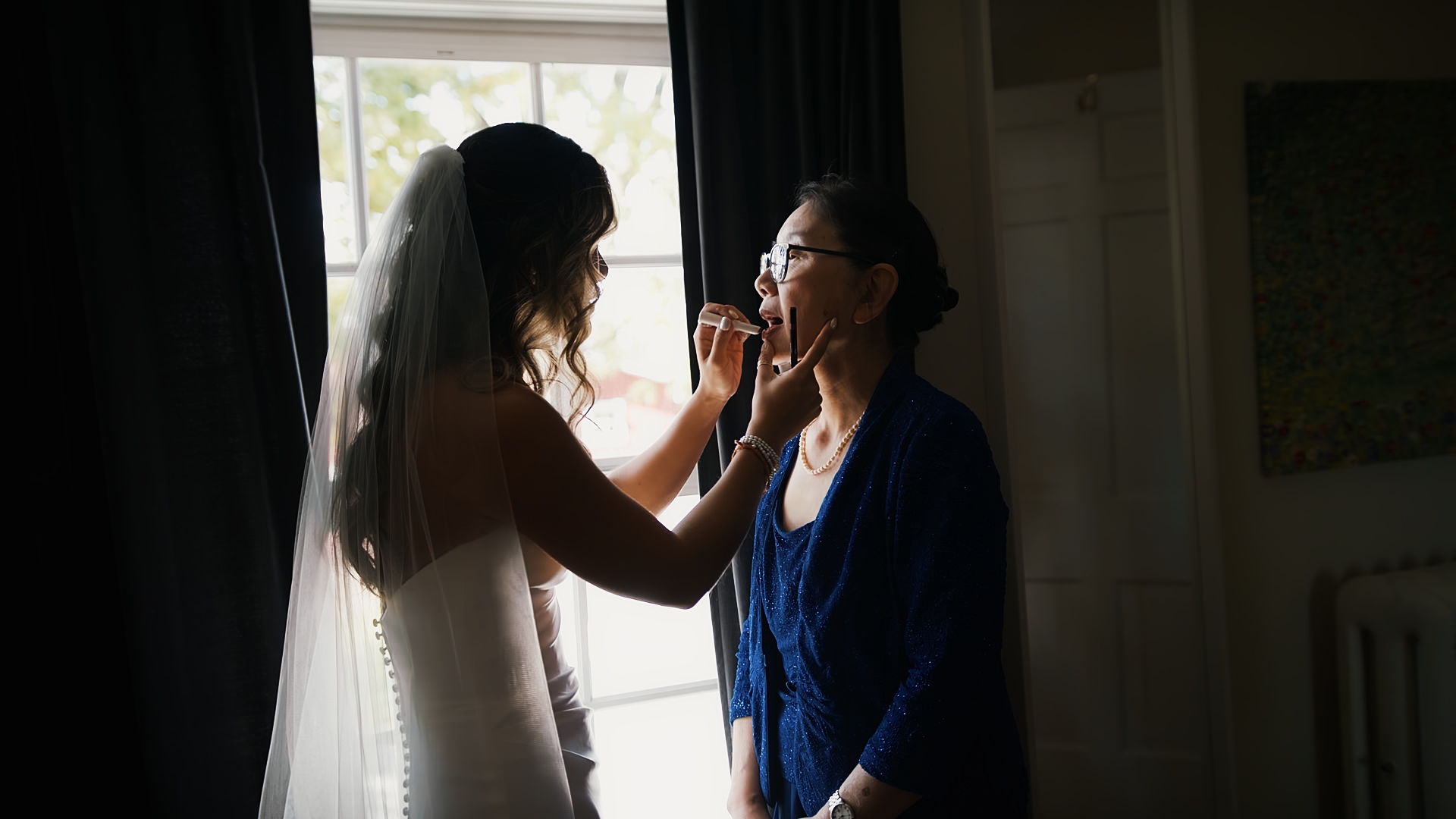 Bride puts makeup on mom at a Cornman Farms Wedding